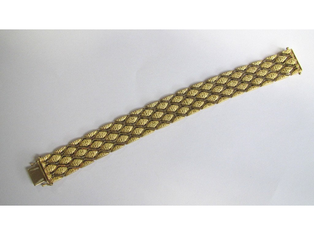 Appraisal: An eighteen carat gold bracelet with diamond shaped matt textured