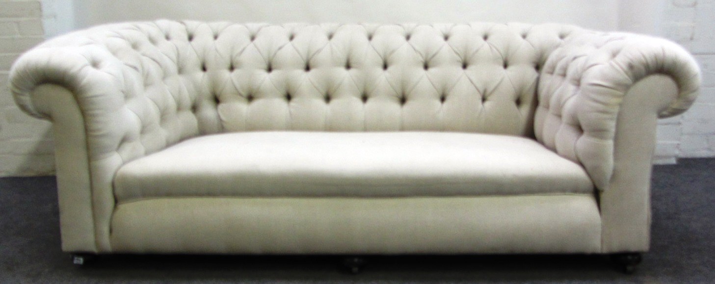 Appraisal: A cream upholstered button back drop end sofa on bun