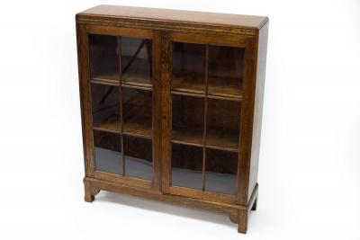 Appraisal: An oak bookcase enclosed by glazed panel doors cm wide