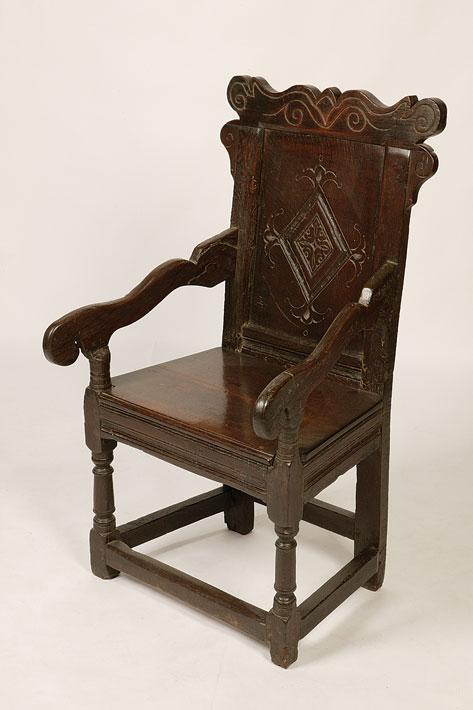 Appraisal: A CHARLES II OAK WAINSCOTE ARMCHAIR the panelled back with