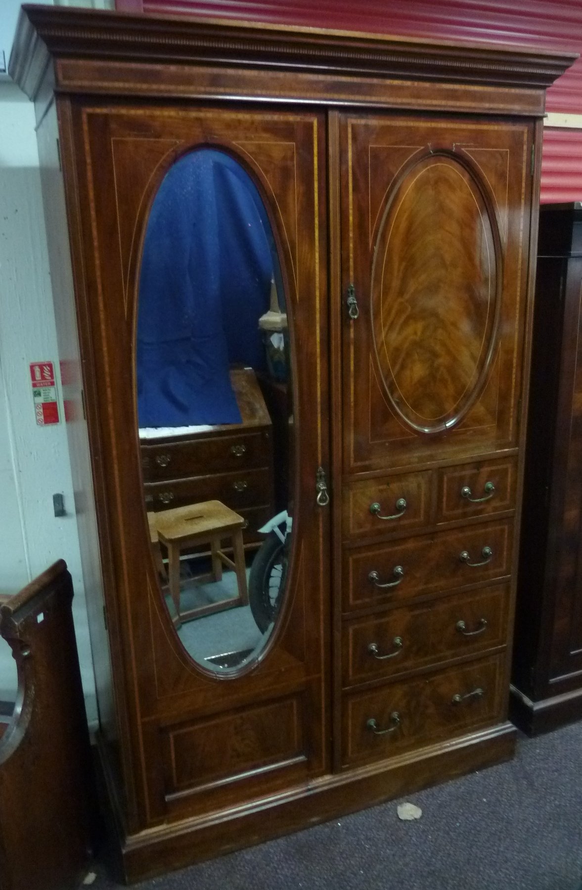 Appraisal: An Edwardian mahogany and satinwood crossbanded wardrobe with oval mirrror