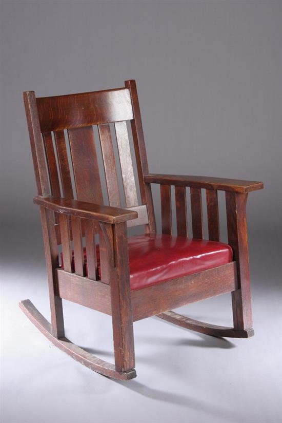 Appraisal: AMERICAN MISSION-STYLE OAK ROCKER Early th century Vertical slat-back flanked