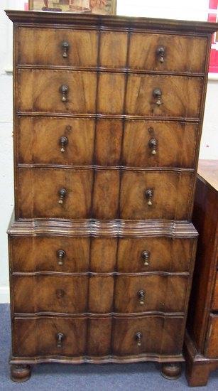 Appraisal: A walnut serpentine front tallboy fitted seven drawers on bun