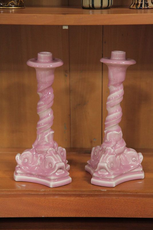 Appraisal: PAIR OF ROOKWOOD CANDLESTICKS Pink glazed sticks with dolphin decoration