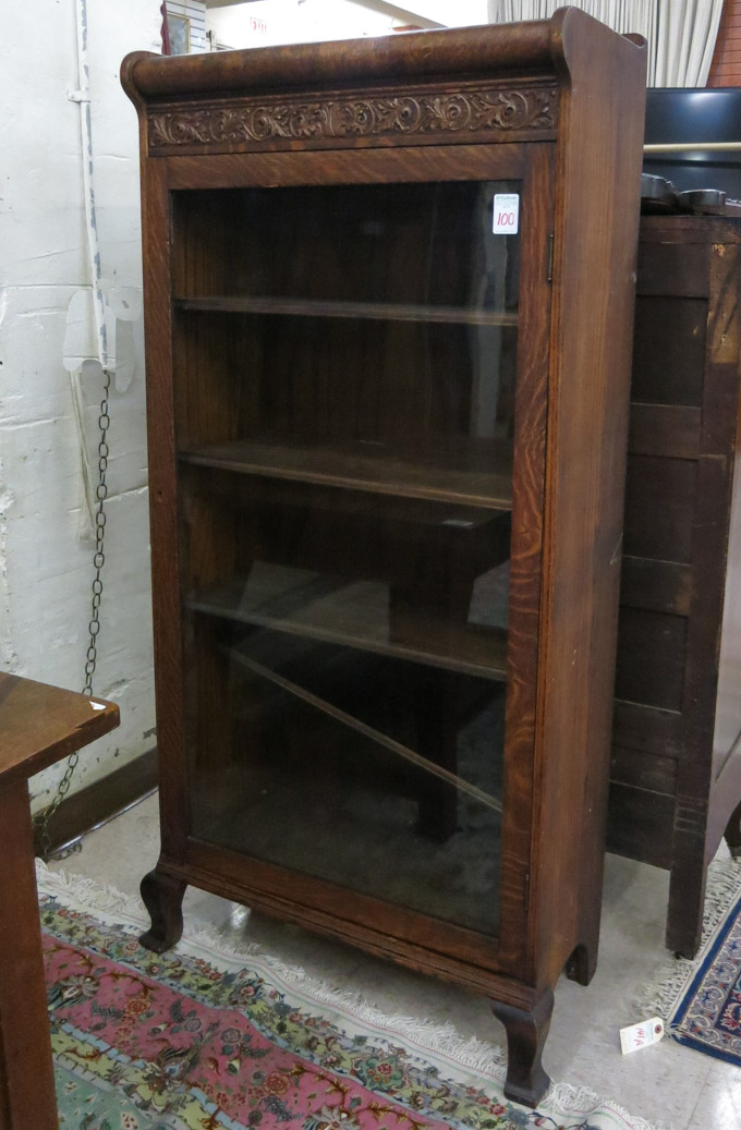 Appraisal: A BROWN OAK CABINET BOOKCASE American c having a carved