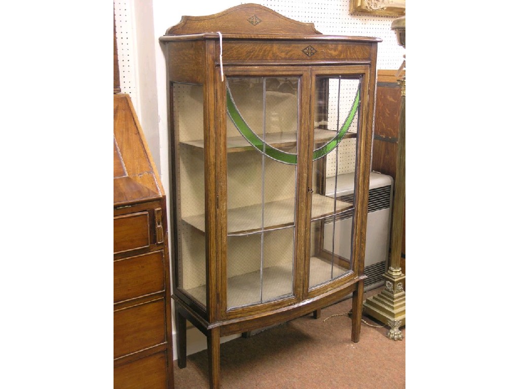 Appraisal: An Edwardian inlaid oak display cabinet bow fronted with lined