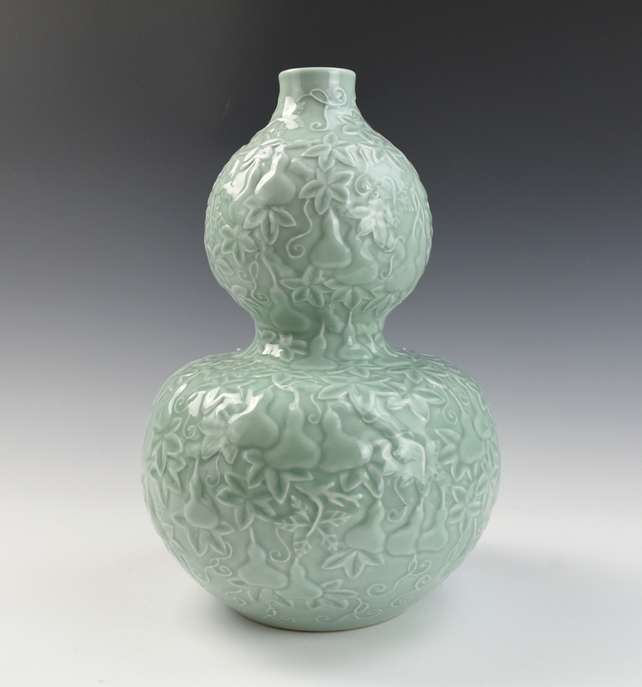 Appraisal: CHINESE CELADON-GLAZED GOURD VASE W QIANLONG MARK the exterior moulded