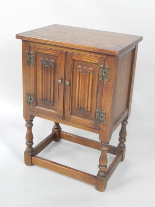 Appraisal: An Old Charm oak linen fold bedside cupboard with two