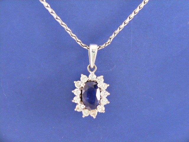 Appraisal: A ct white gold sapphire and diamond cluster pendant on