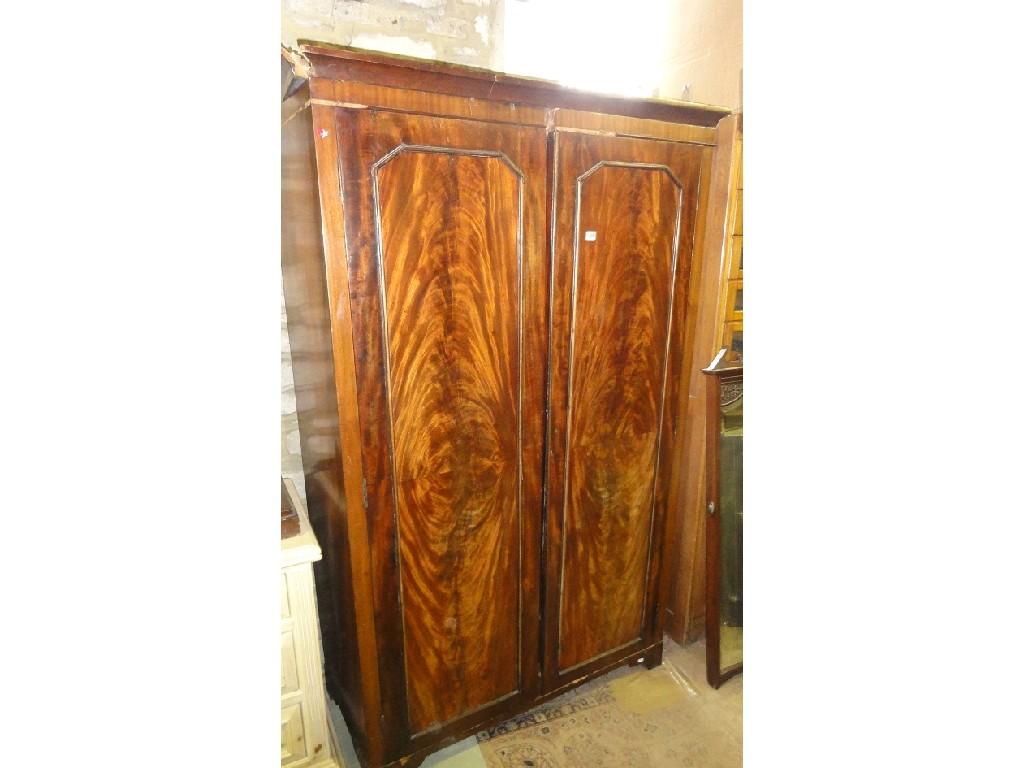 Appraisal: A th century mahogany two sectional wardrobe enclosed by a