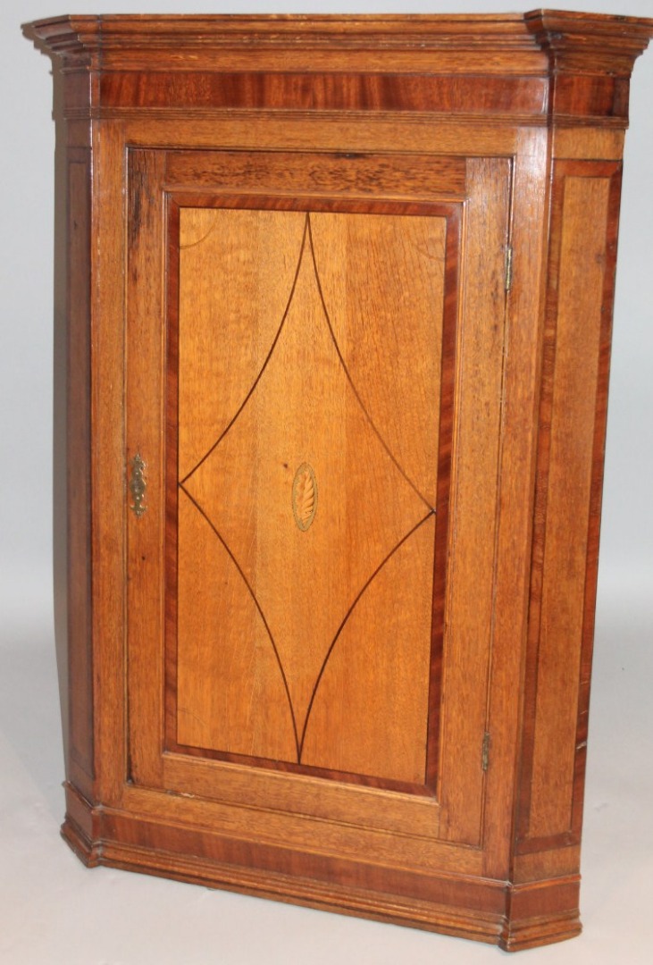 Appraisal: An thC oak and mahogany corner cupboard the inverted cornice