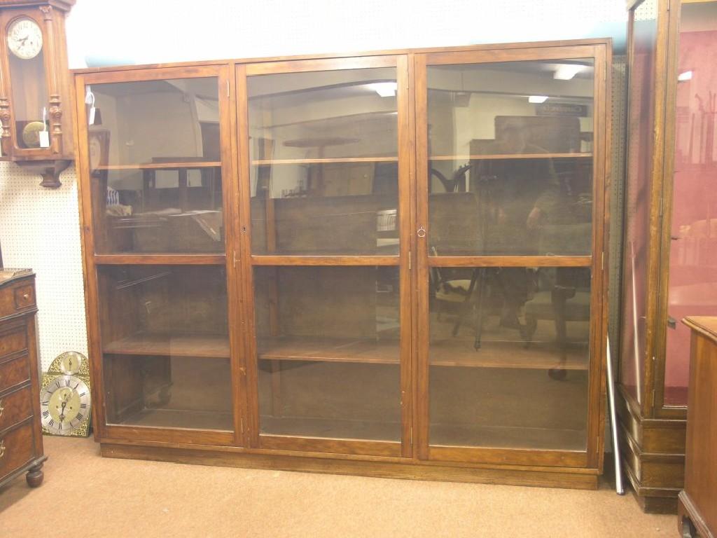 Appraisal: A large dark-stained pine bookcase three shelves enclosed by three