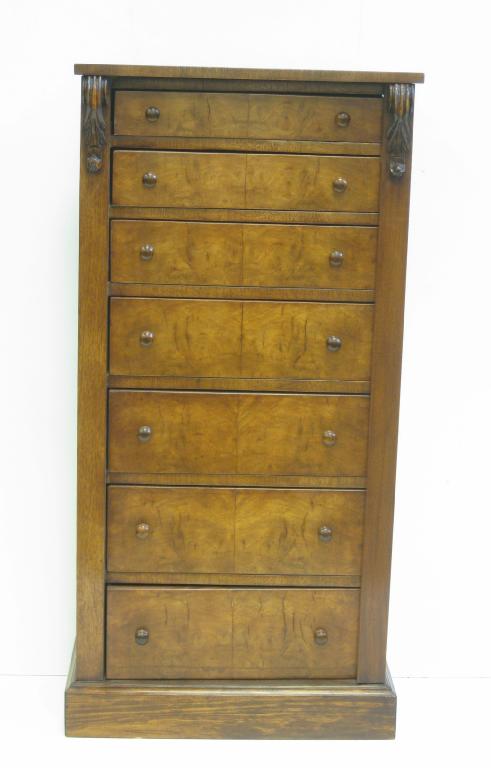 Appraisal: A walnut Wellington Chest of seven drawers flanked by scroll