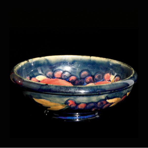 Appraisal: MOORCROFT Bowl in the Pomegranate pattern on indigo Stamped MOORCROFT