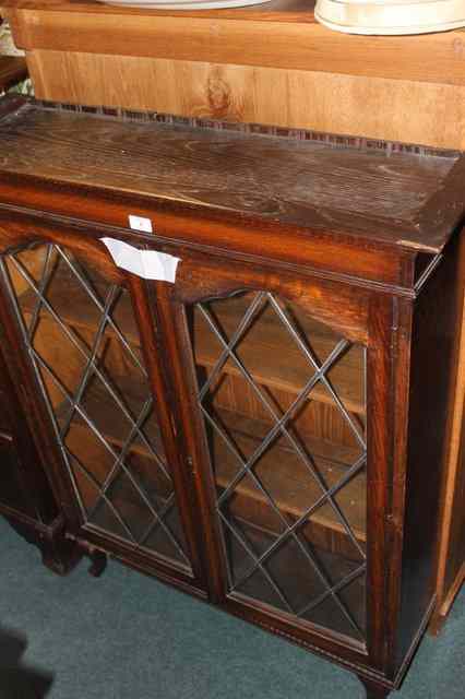 Appraisal: A SMALL OAK DISPLAY CABINET enclosed by two glazed panel