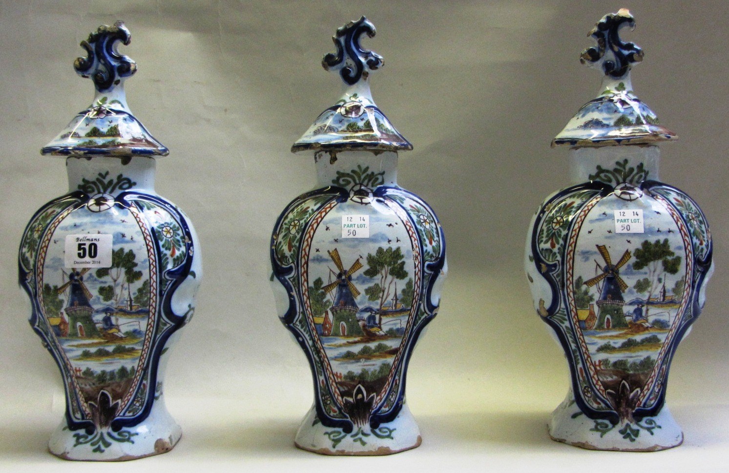 Appraisal: A garniture of three Dutch Delft polychrome vases and covers