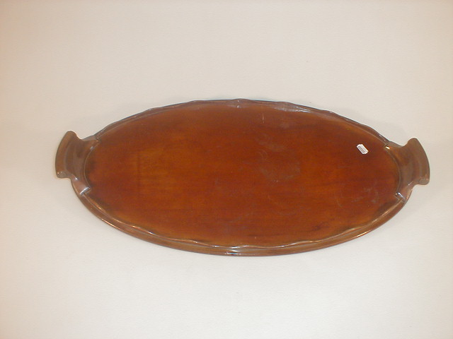 Appraisal: A mahogany tea tray of oval form with a wavy