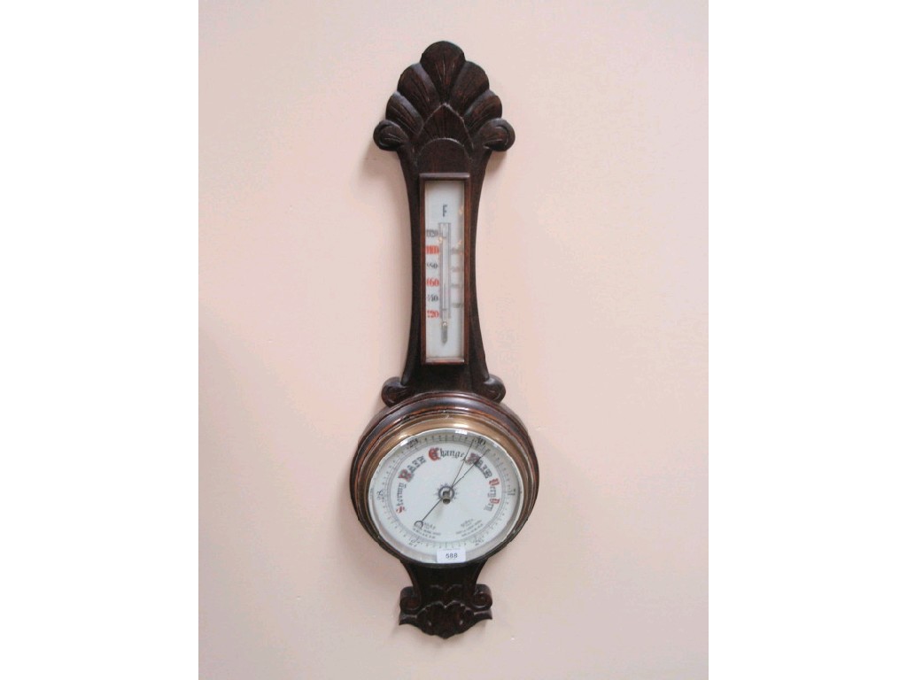 Appraisal: A late Victorian aneroid wheel barometer with thermometer in carved