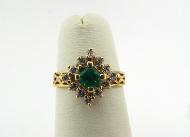 Appraisal: K yellow gold ring with emerald center stone and twelve