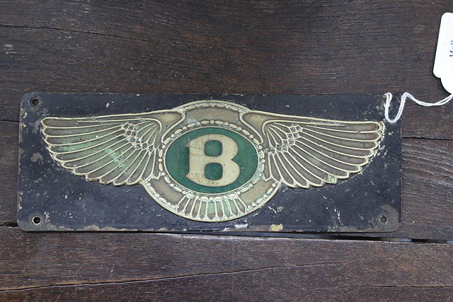 Appraisal: A BLACK PAINTED AND GREEN ENAMEL DECORATED BENTLEY FIREWALL EMBLEM