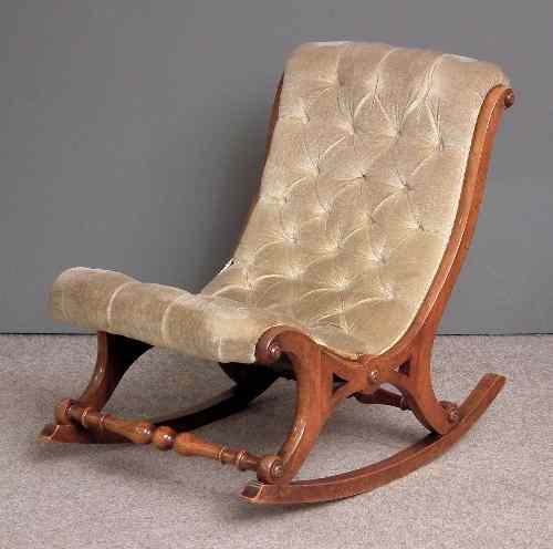 Appraisal: A Victorian walnut framed rocking nursing chair of scrolled shape