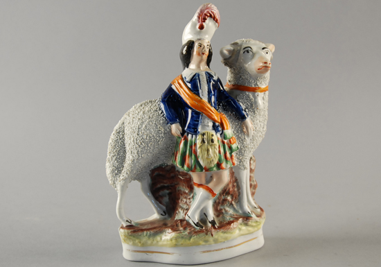 Appraisal: A Staffordshire Figure of a Scotsman standing with a very