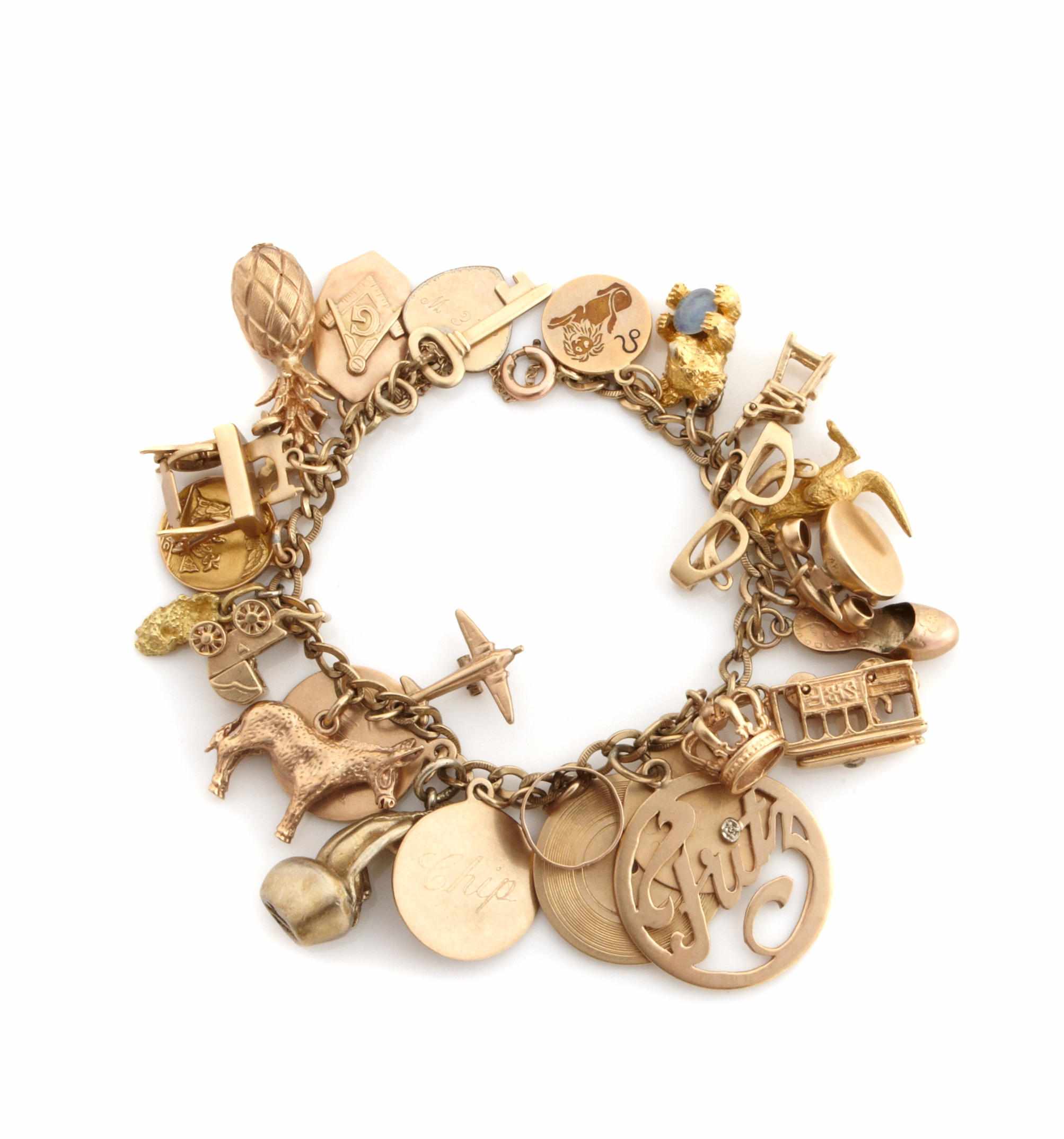 Appraisal: A gold charm bracelet including animal fruit and sunglasses charms