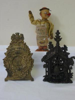 Appraisal: A cast iron money bank the front as an arbor