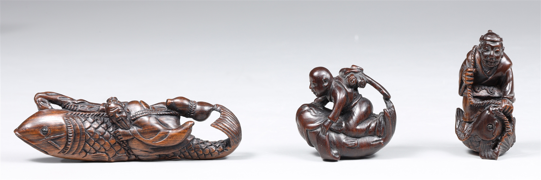 Appraisal: Group of three carved wood netsuke including Ocean traveler on