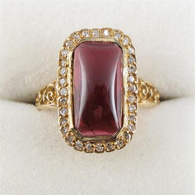 Appraisal: A garnet and diamond set gold ring The cabochon garnet