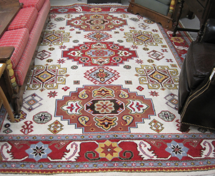 Appraisal: HAND KNOTTED ORIENTAL CARPET Indo-Caucasian featuring three geometric medallions among