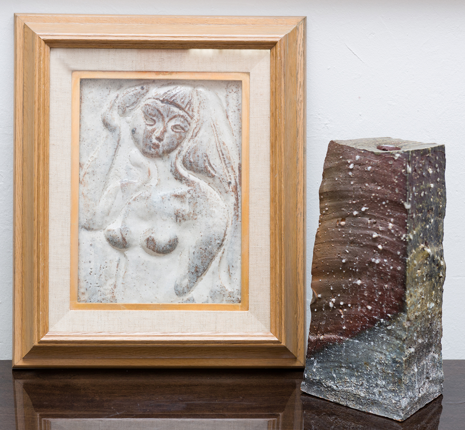 Appraisal: A FRAMED EARTHENWARE FEMALE NUDE RELIEF WITH A CREAM GLAZE