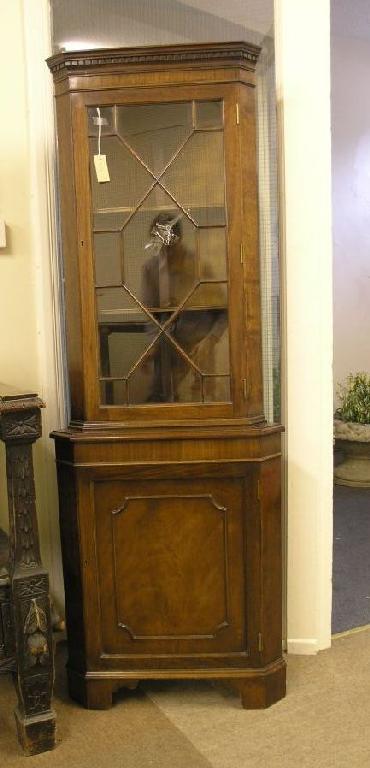 Appraisal: A reproduction mahogany corner cabinet astragal glazed door enclosing two