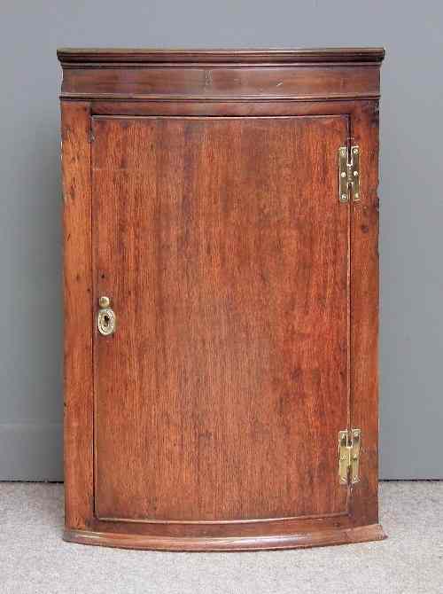 Appraisal: An th Century oak bow-front hanging corner cupboard with moulded