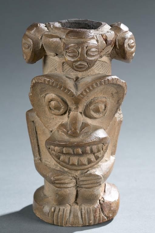 Appraisal: Terracotta pipe with multiple faces A terracotta pipe with multiple