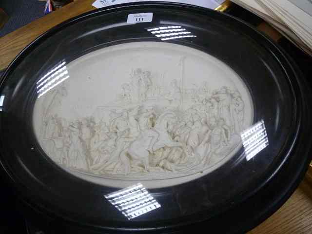 Appraisal: AN OVAL PLASTER RELIEF SCULPTURE depicting the Crucifixion within a