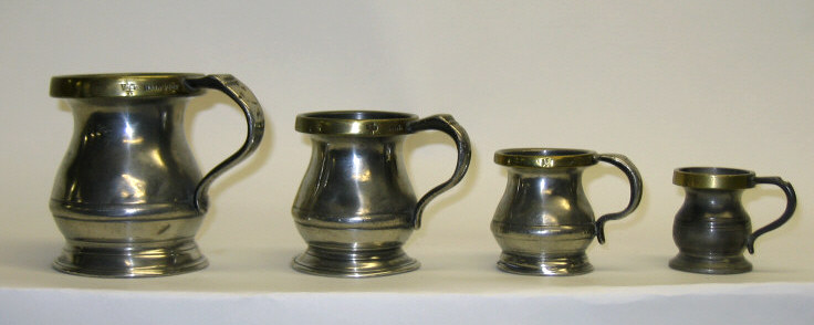 Appraisal: FOUR ENGLISH PEWTER MEASURING TANKARDS Each handled baluster with brass