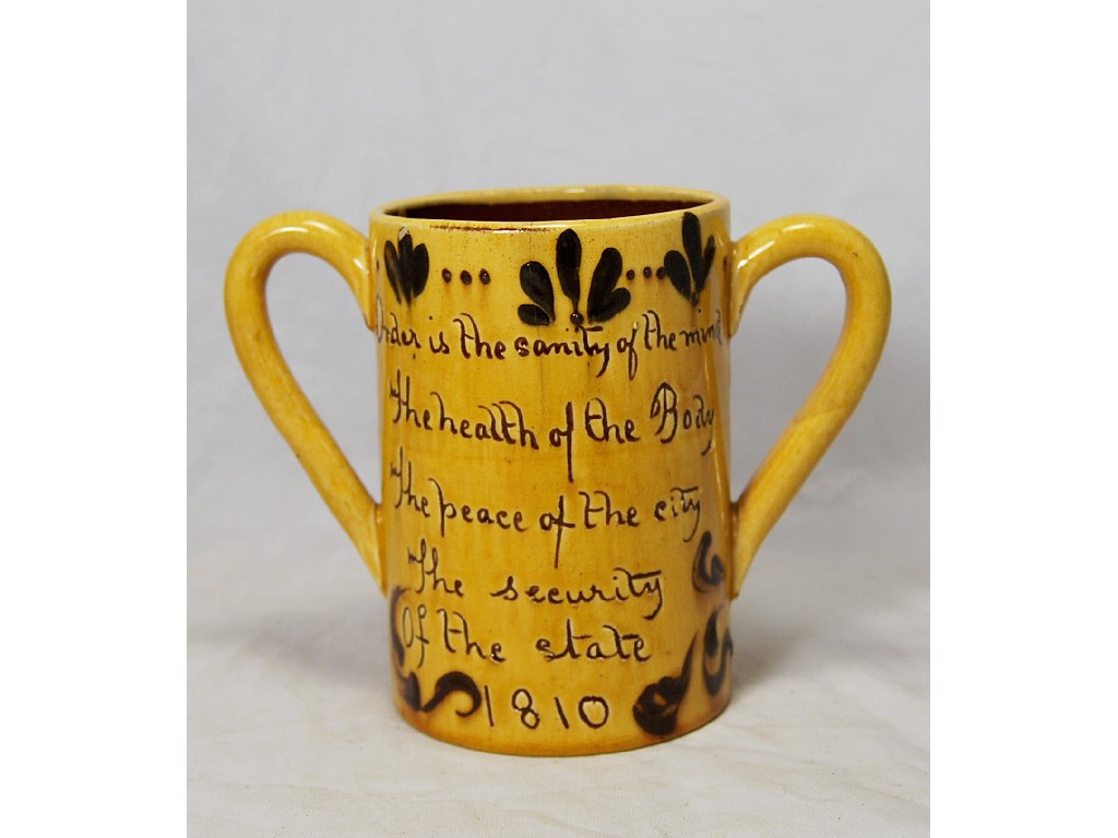 Appraisal: A slip-decorated earthenware two-handled mug with quotation from Robert Southey