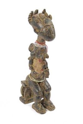 Appraisal: An Ashanti fertility figure seated on a stool with a