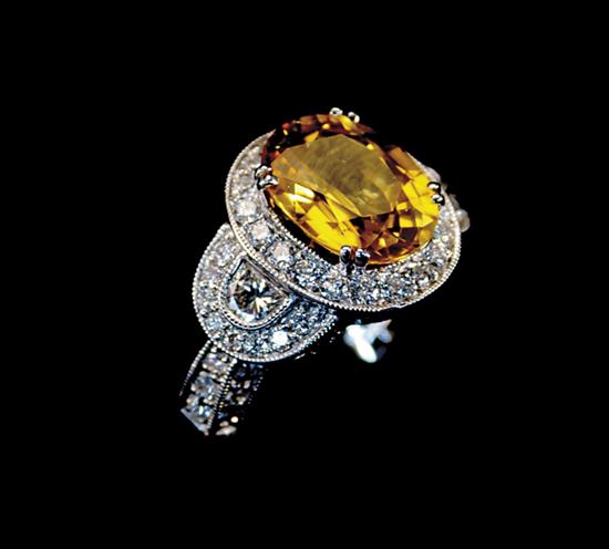 Appraisal: Yellow sapphire and diamond dinner ring centered by oval yellow