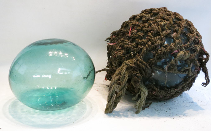 Appraisal: TWO JAPANESE GLASS FISHING FLOATS the first with rope netting