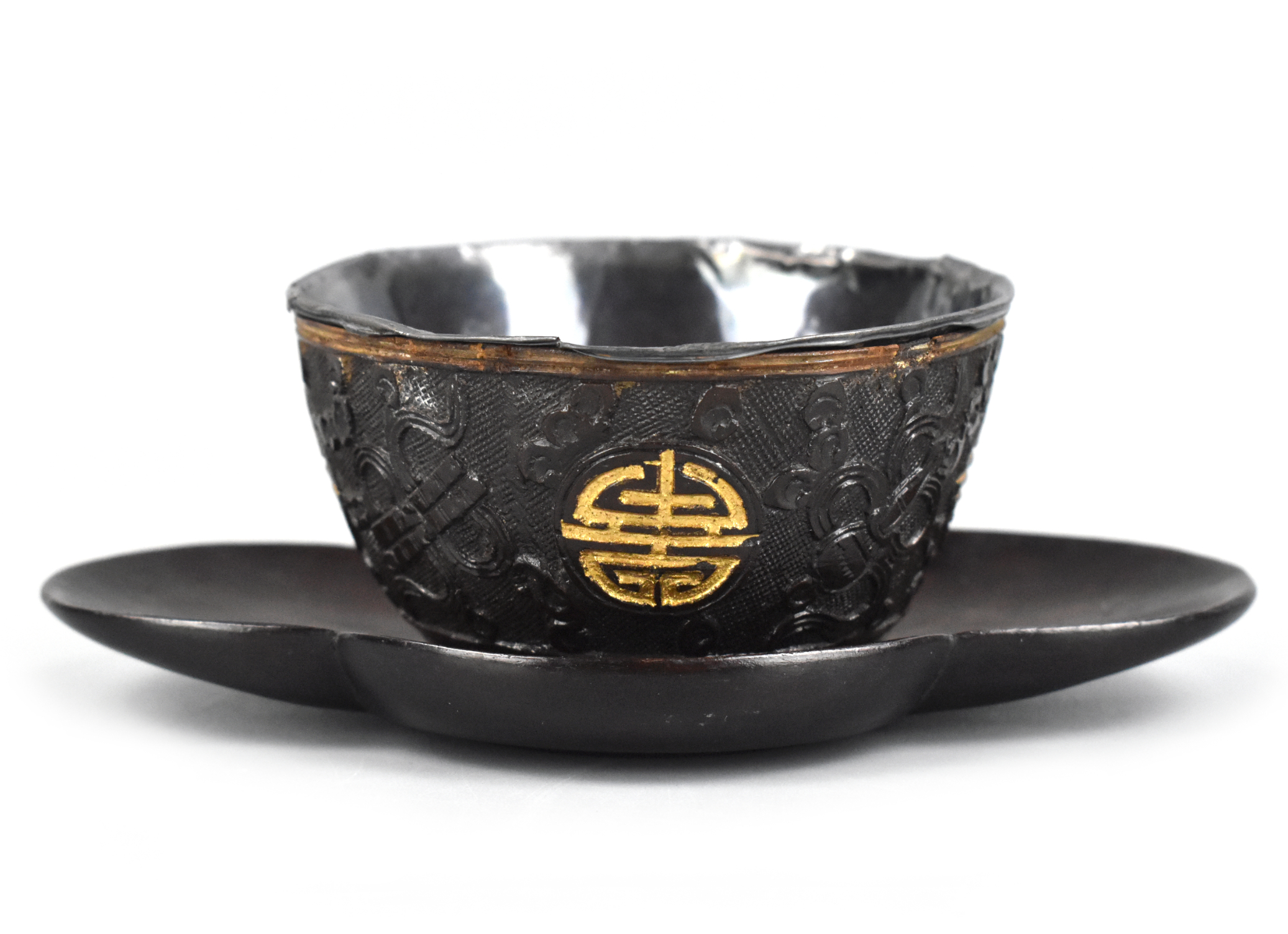 Appraisal: A Chinese gild coconut shield carved cup with Shou symbol