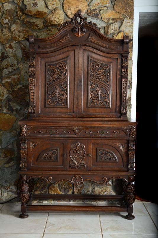 Appraisal: CONTINENTAL CARVED CUPBOARD Step back blind cabinet shaped pediment with