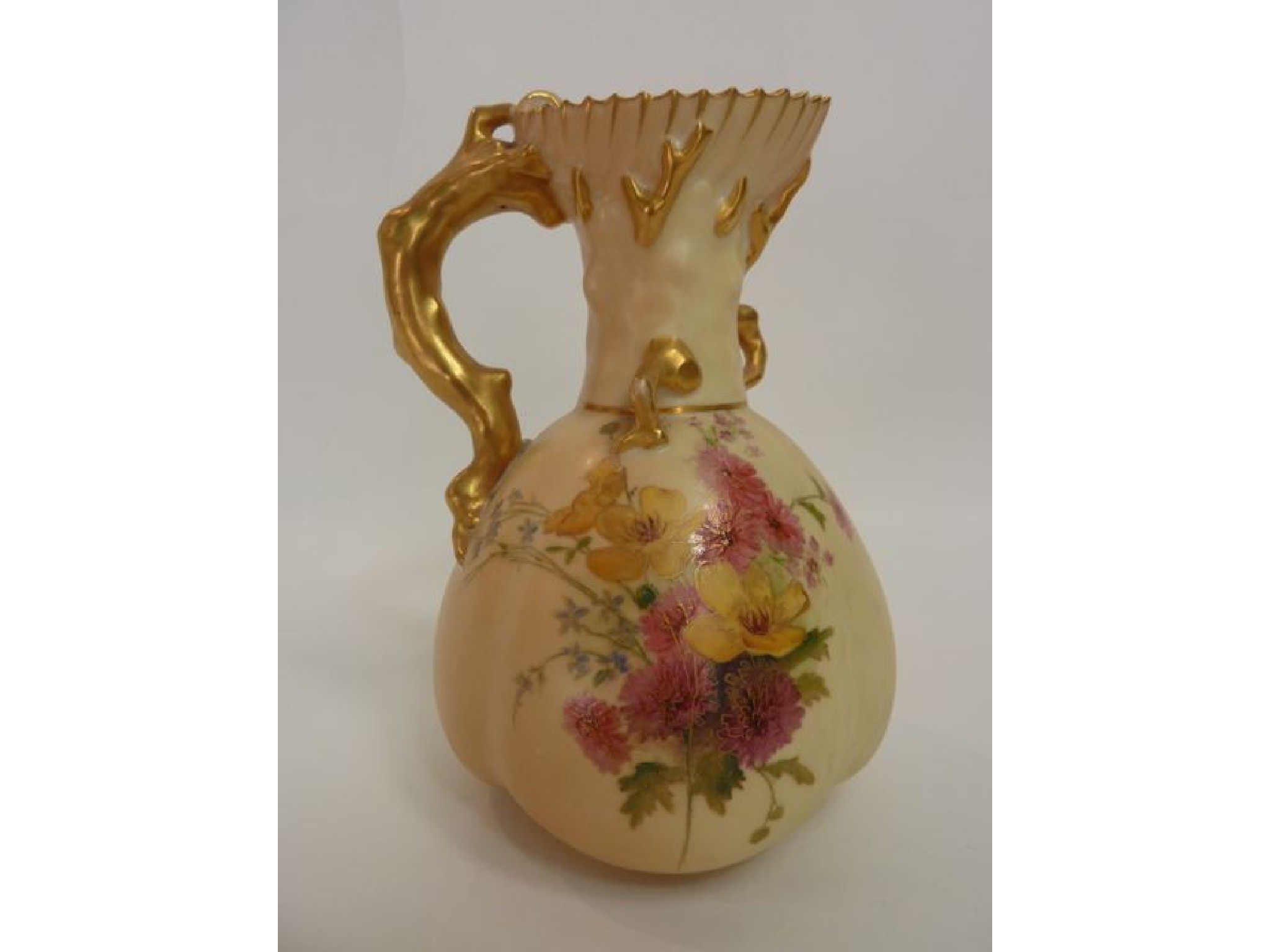 Appraisal: A Royal Worcester blush ivory jug with gilded rustic handle