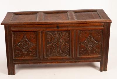 Appraisal: A late th Century carved oak chest with triple-panel hinged