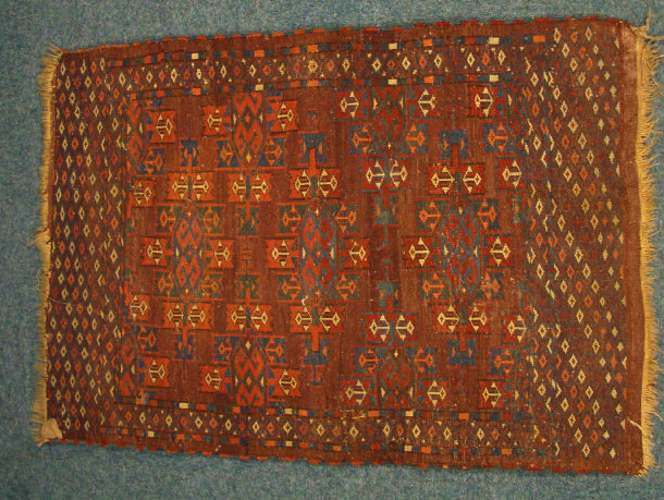 Appraisal: Rectangular brown ground mat decorated with geometric blue cream and