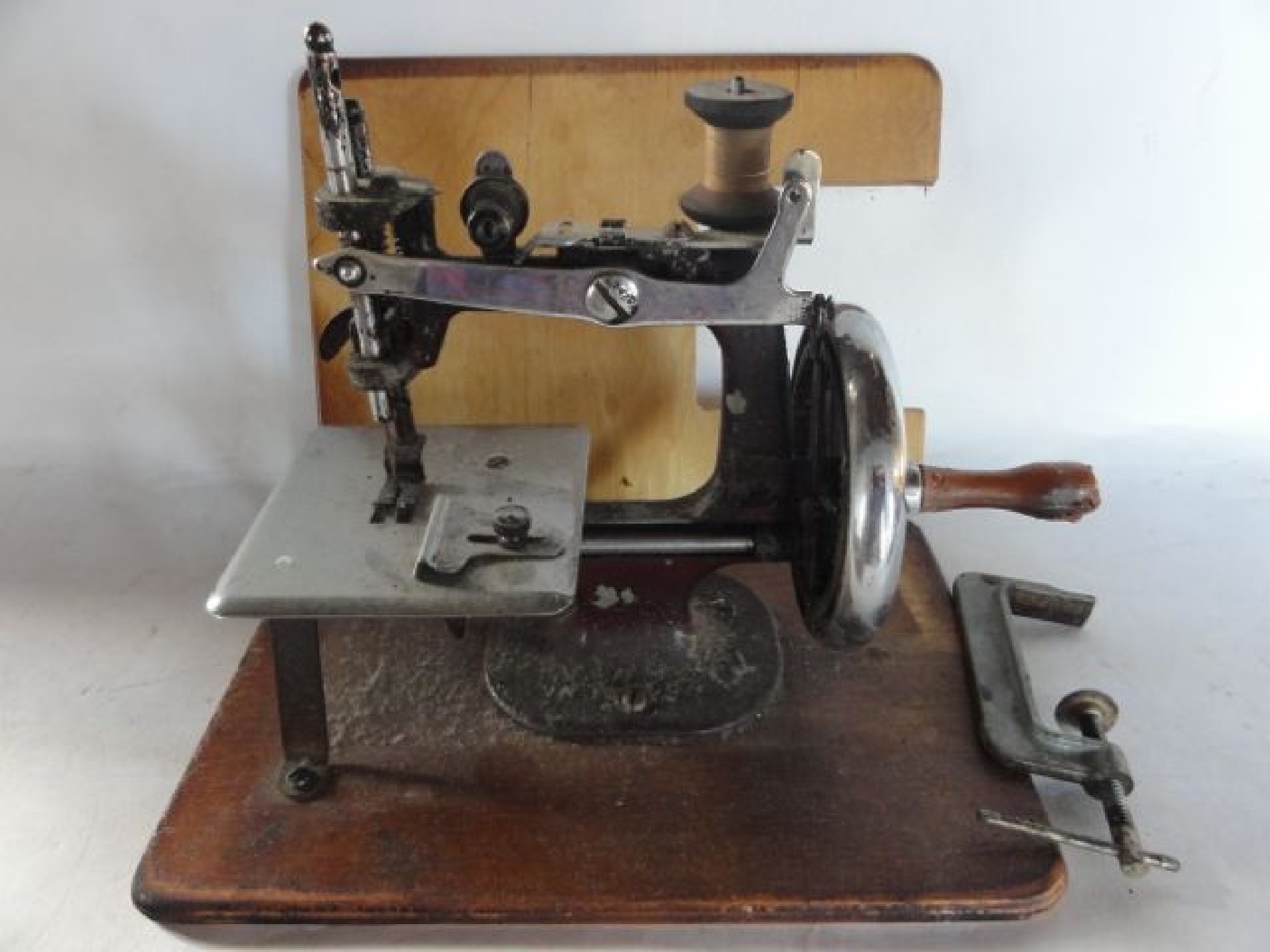 Appraisal: A th century miniature sewing machine mounted on a plywood