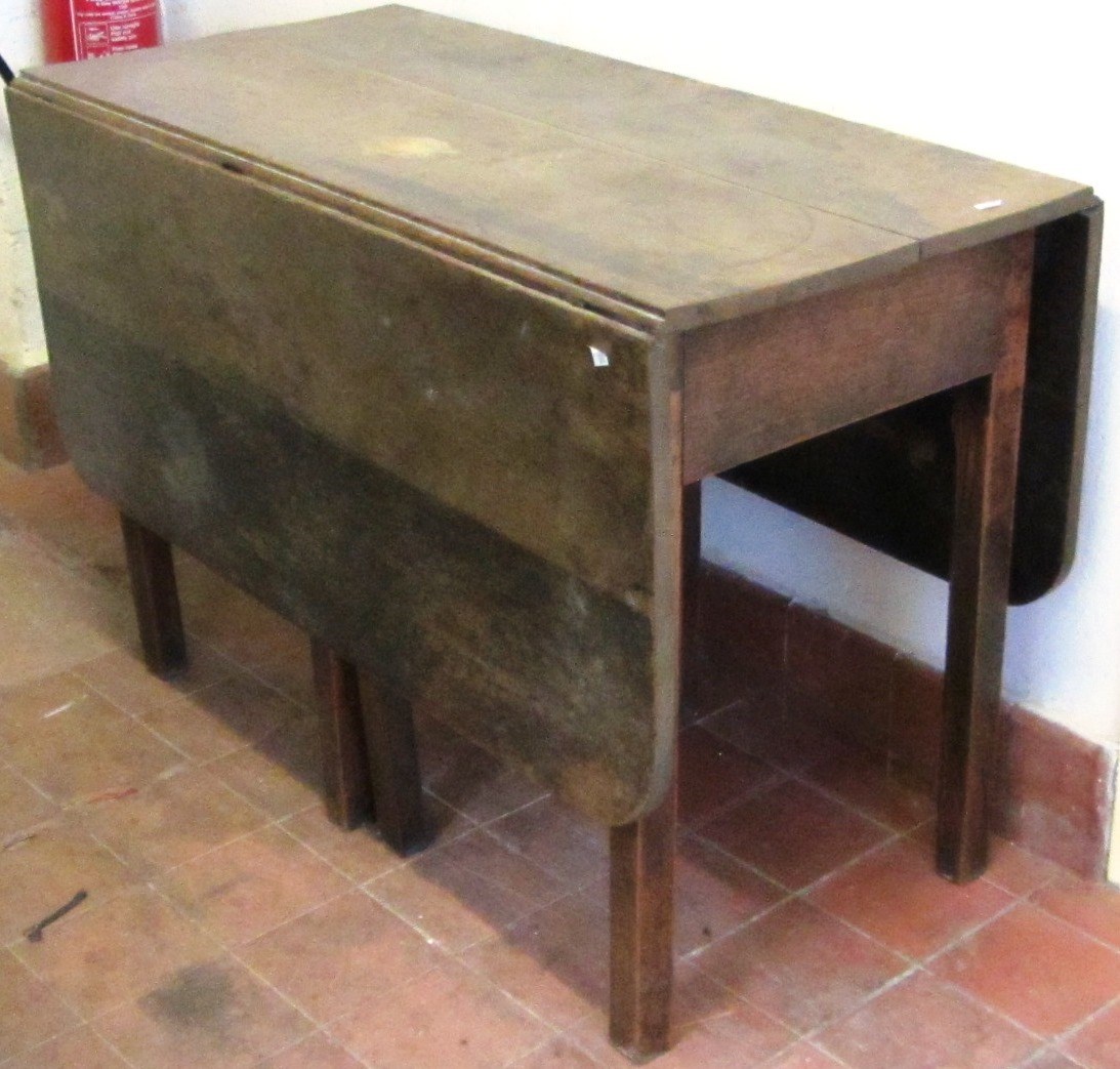 Appraisal: A George III oak drop flap table on block supports