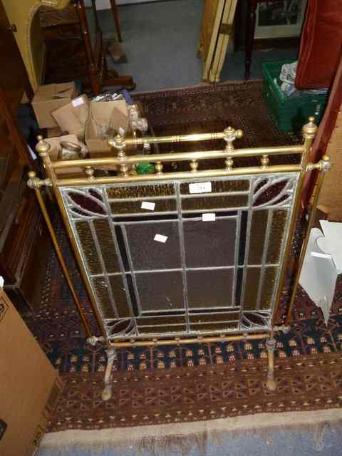 Appraisal: A TURNED BRASS AND LEADED GLASS FIRE SCREEN wide