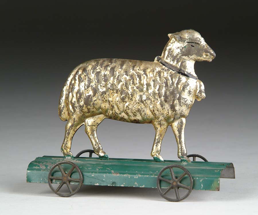 Appraisal: AMERICAN TIN SHEEP PLATFORM TOY A japanned woolly sheep affixed